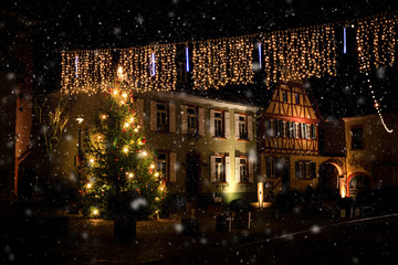 Romantic, illuminated Christmas tree during snowfall in the market square of Nierstein