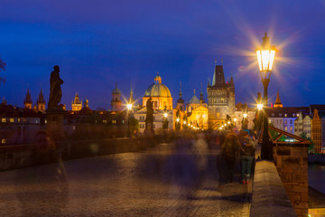 Fototapeta na wymiar Summer night walking by illuminated Charles Bridge, Prague, Czech Republic