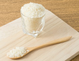 Uncooked Japanese Rice in Wooden Spoon and Glass Cup