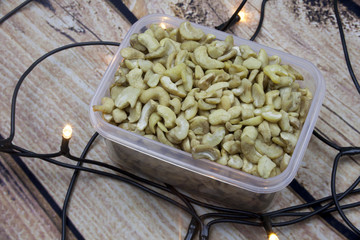 Cashew nuts on brown wooden background, side view with lights