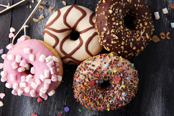 assorted donuts with chocolate frosted, pink glazed and sprinkles donuts.