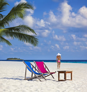 Sch&ouml;ner Maledivenstrand mit Model und Sonnenliegen