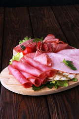Food tray with delicious salami, pieces of sliced ham, sausage, tomatoes, salad and vegetable - Meat platter with selection