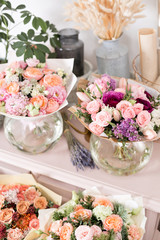 Few of beautiful luxury bouquet. Mixed flowers on pink table. the work of the florist at a flower shop. Wedding