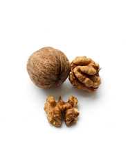 Whole walnuts in shell and chopped walnuts isolated on white background. A few nuts. Healthy foods