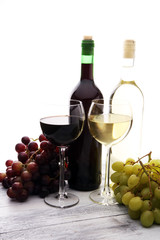 Glasses of wine and grapes on wooden background. red and white wine concept