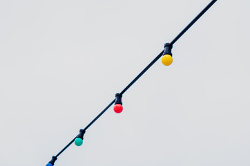 Colorful lightbulb in the row hanging in the sky