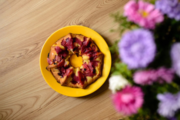 Apple pie and flowers on the table.