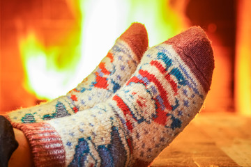 Man's Feet in  socks, before  cozy fireplace, in cozy country house.