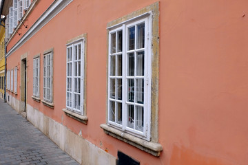 Fototapeta na wymiar Facade and windows of the old building with colored walls