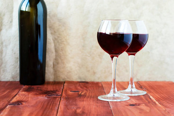 Two glasses of red wine on a wooden table