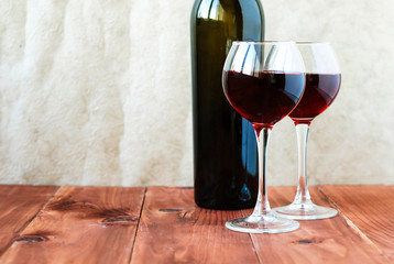 Two glasses of red wine on a wooden table
