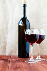 Two glasses of red wine on a wooden table