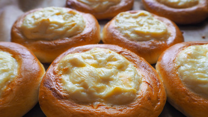 Hot buns with cream cheese on a baking sheet. Homemade pastries.
