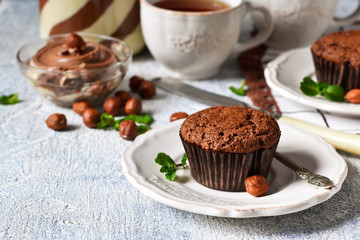 Chocolate muffins with nuts and peanut butter on a concrete background