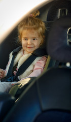 family, transport, road trip concept - portrait smiling girl sitting in the car seat.