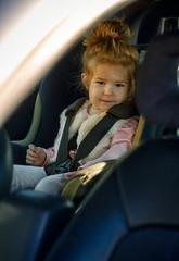 family, transport, road trip concept - portrait girl sitting in the car seat.