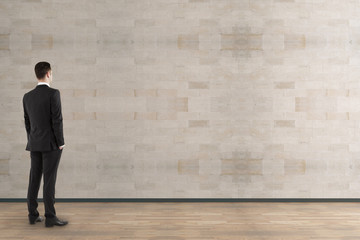 Businessman looking at empty wall