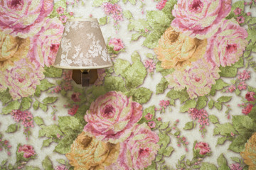 Lamp on a background of floral wallpaper. Including copy space