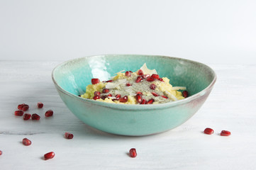 Superfood millet porridge with matcha chia pudding, pomegranate seeds and coconut flakes
