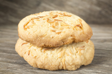 Two coconut cookies on the wooden background