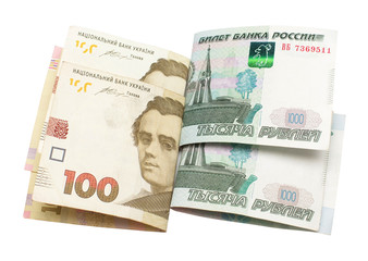 One hundred Ukrainian national currency hryvnia and one thousand rubles of Russian isolated on white background. Finance, international politics