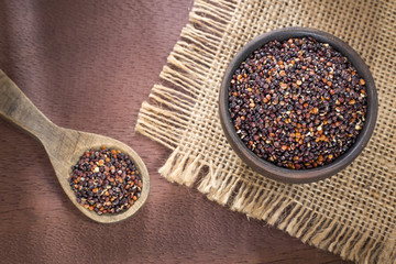 Black quinoa in the wooden bowl and spoon.