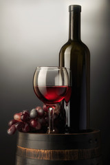 red wine bottle and wine glass on wodden barrel