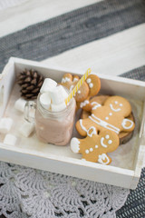 Stylish Christmas interior in gray and blue tones. Comfort and coziness in the house. Christmas gingerbread cookies and a cup of hot chocolate