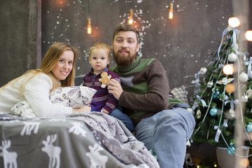 happy family of three people gathered in front of a Christmas tree. Christmas decorations