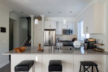 Modern white kitchen with stainless steel appliances. Interior design.
