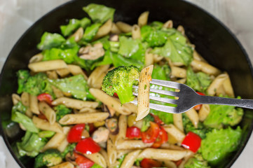 pasta with vegetables cooked in a frying pan, closeup