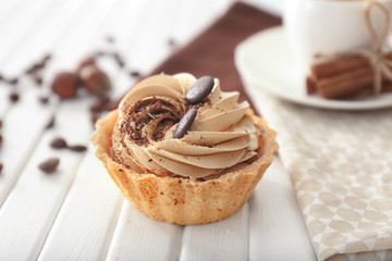 Tasty tartlet with whipped cream on wooden table