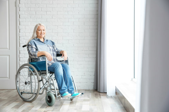 Mature woman in wheelchair indoors