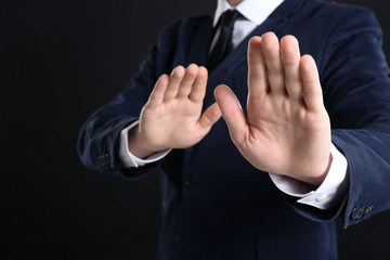 Businessman refusing to take bribe on black background