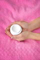 Woman with jar of body cream at home