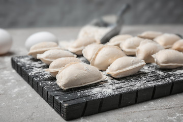 Raw dumplings on wooden board, closeup