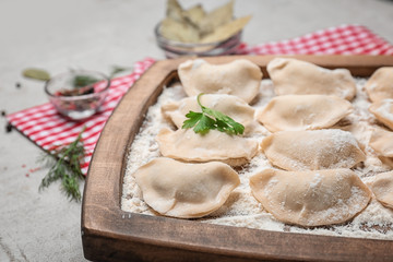 Raw dumplings on wooden board, closeup