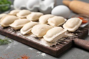 Raw dumplings on wooden board, closeup