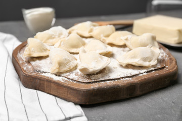 Raw dumplings on wooden board, closeup