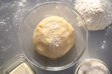Bowl with raw dough on table