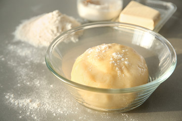Bowl with raw dough on table