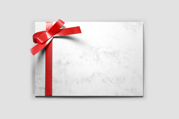 Blank greeting or thank you card decorated with red ribbon 
