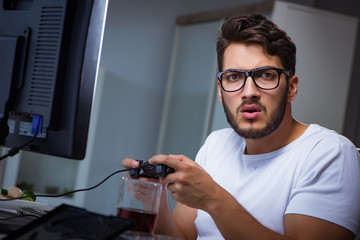 Young man playing games long hours late in the office