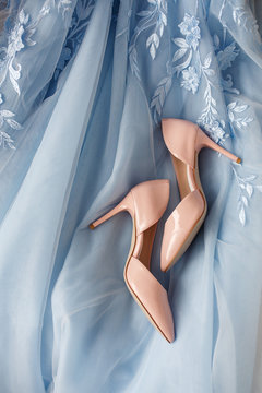 Pink bridal shoes on high heels on blue wedding dress. Marriage and wedding concept