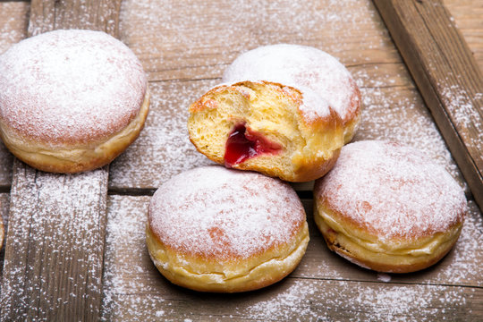 Traditional Polish donuts on wooden powder. Tasty doughnuts with jam.