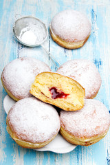 Traditional Polish donuts on wooden powder. Tasty doughnuts with jam.