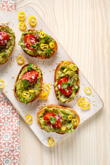Sandwiches with guacamole, cherry tomatoes, onions, chili peppers and fresh coriander. A delicious and healthy vegetarian appetizer