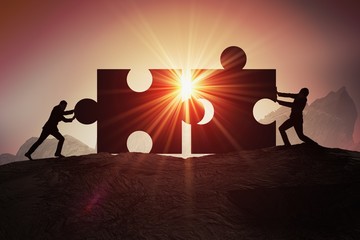 Teamwork, partnership and cooperation concept. Silhouettes of two businessman joining two pieces of...