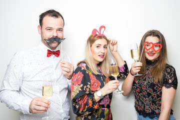three people girls man posing party props photo booth white plain background studio hat